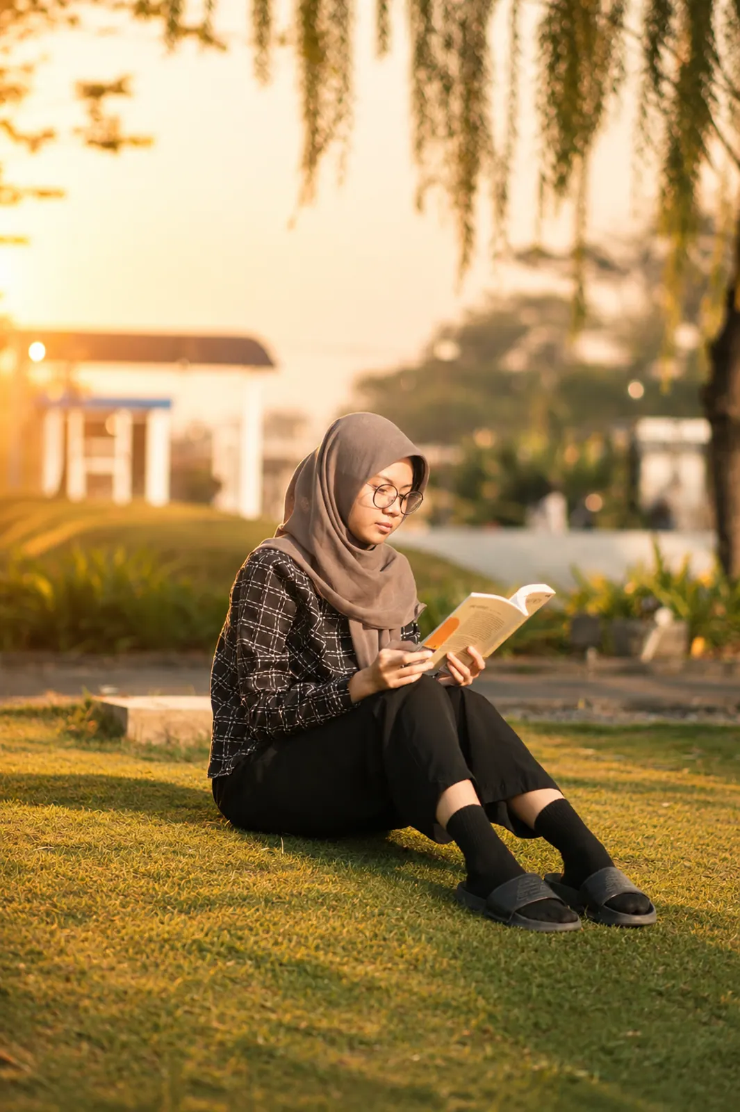 A close portrait of a woman reading outdoors in the evening light