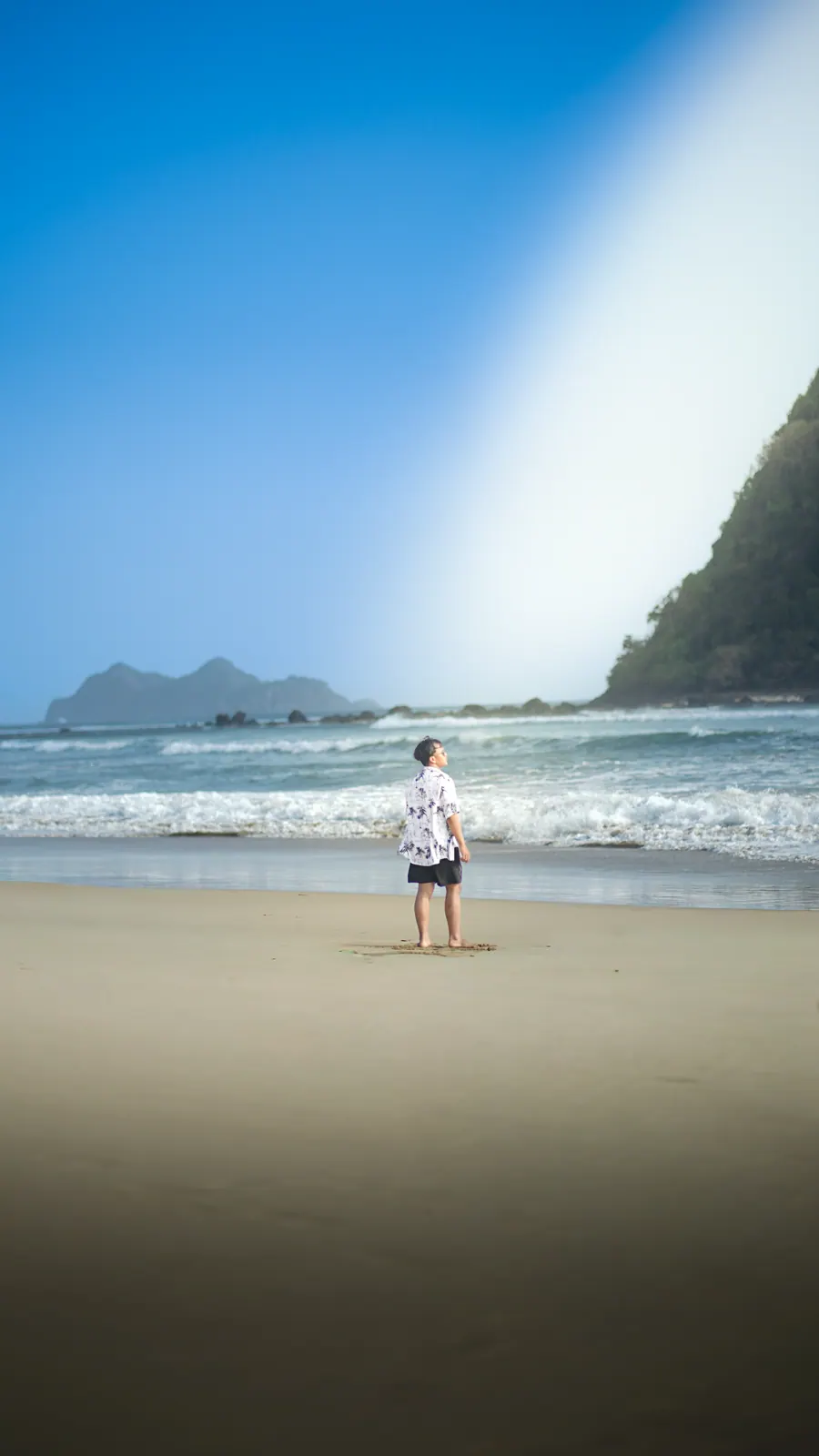 Ahmad Farrel standing near the breaking waves at Red Island
